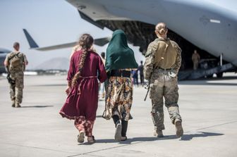 La marine Nicola Gee mentre scorta due donne afghane su un aereo nello scalo di Kabul