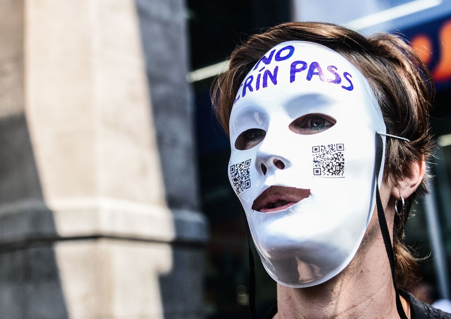 Un manifestante indossa una maschera bianca con la scritta Crin (in dialetto piemontese Maiale) Pass