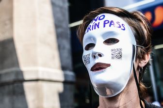 Un manifestante indossa una maschera bianca con la scritta Crin (in dialetto piemontese Maiale) Pass