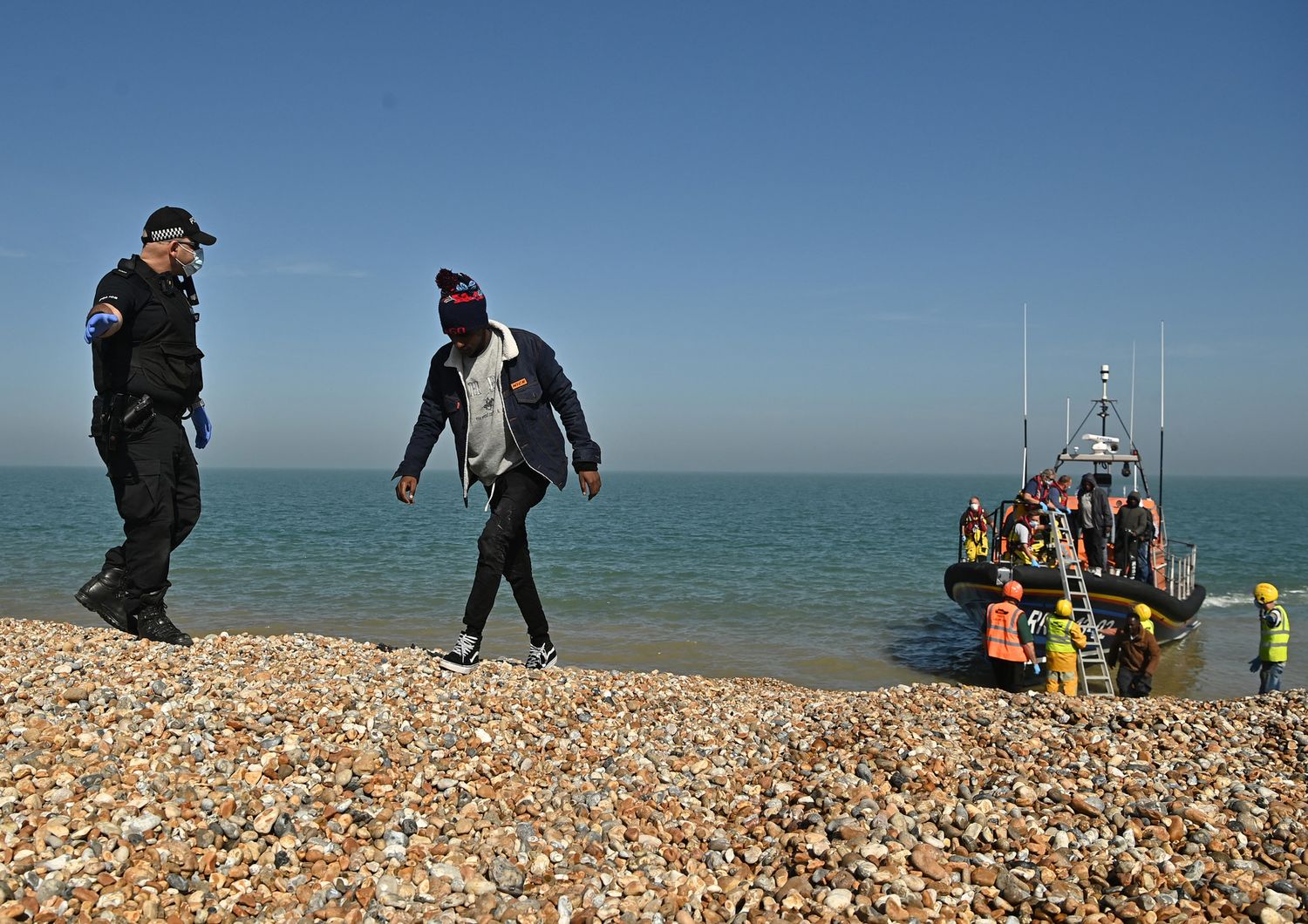 Migranti scortati dalla polizia britannica dopo aver attraversato la Manica