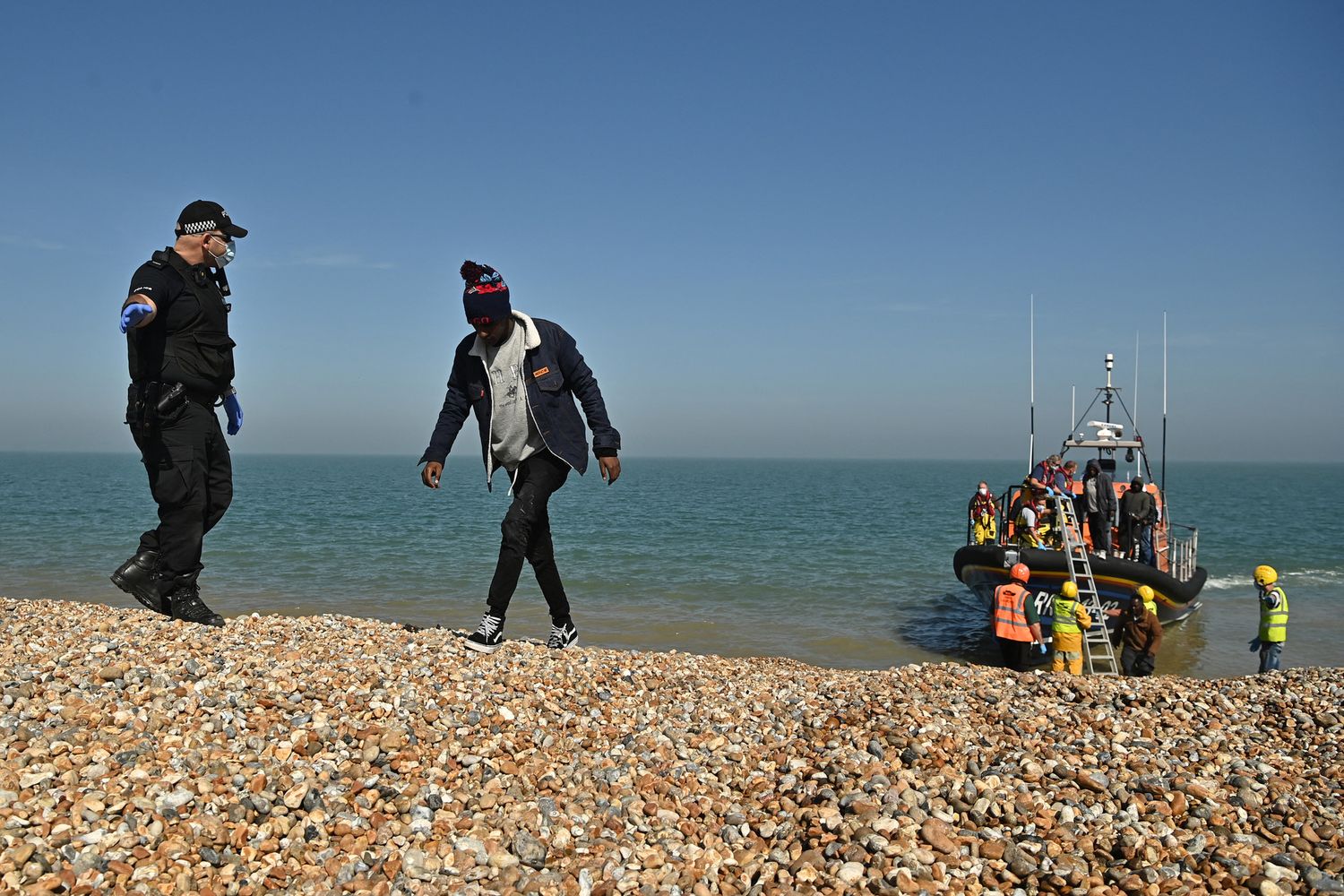 Migranti scortati dalla polizia britannica dopo aver attraversato la Manica