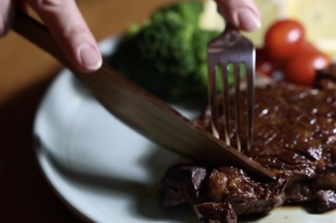 I coltelli di legno che tagliano una bistecca