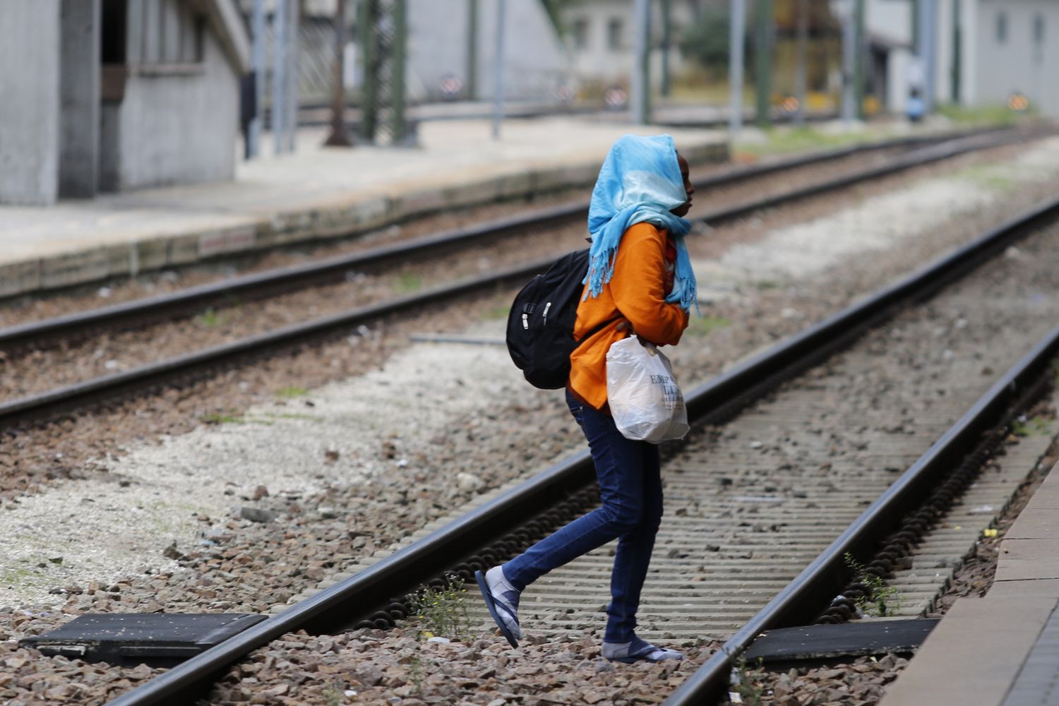 Una migrante attraversa i binari al Brennero