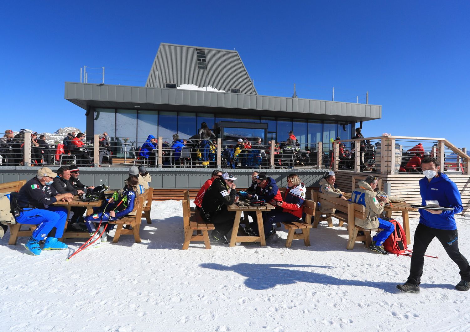 Uno ski bar ai piedi di una pista da sci inondata dal sole a Moena