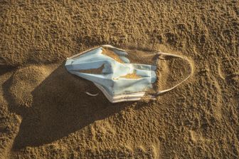 Una mascherina abbandonata in spiaggia