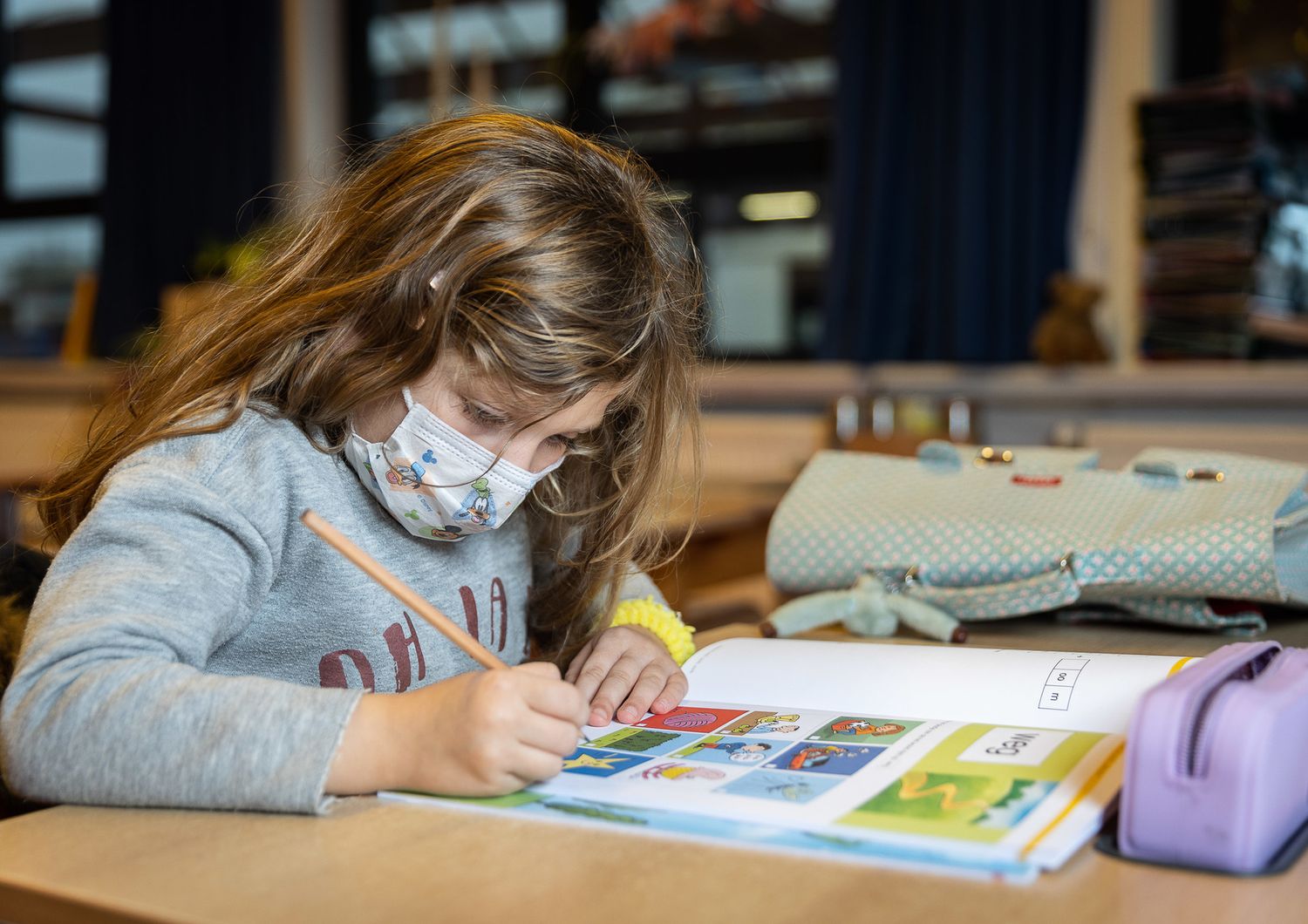 Una bambina disegna a scuola