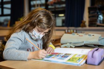 Una bambina disegna a scuola