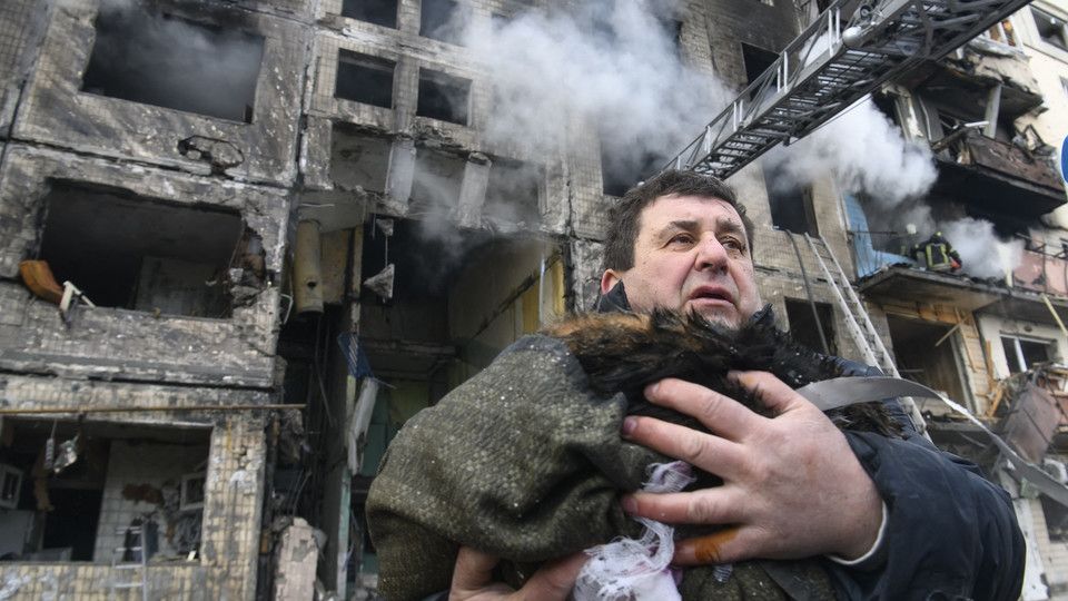 Un uomo porta in salvo il suo gatto dal suo appartamento bombardato