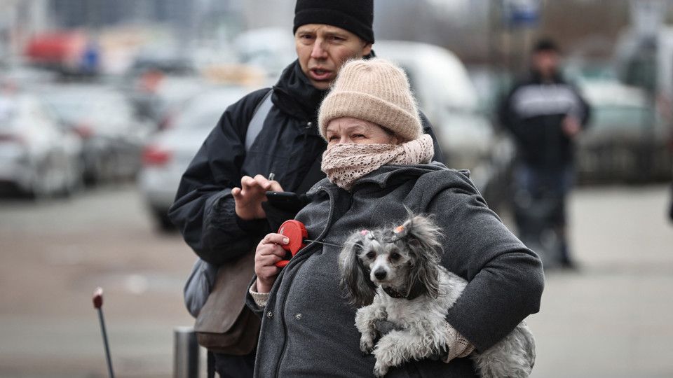 Una donna con in braccio il suo gatto al confine con la Polonia