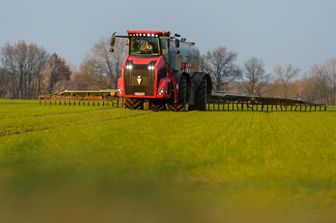 Un trattore sparge concime in un campo