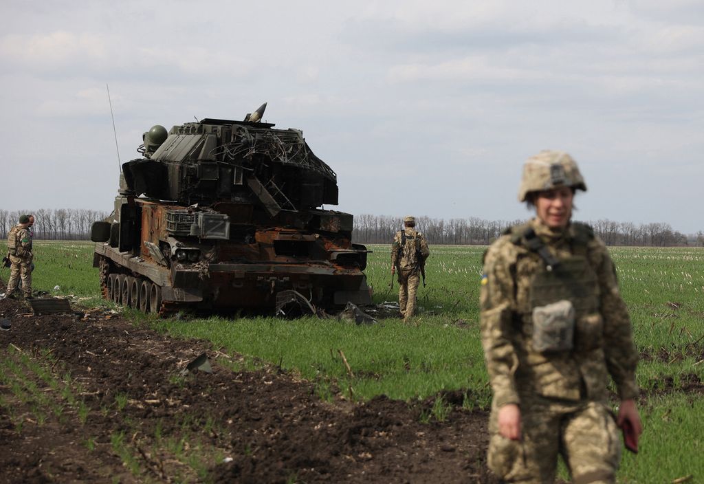 Militari ucraini vicino ad un mezzo russo distrutto vicino Kharkiv