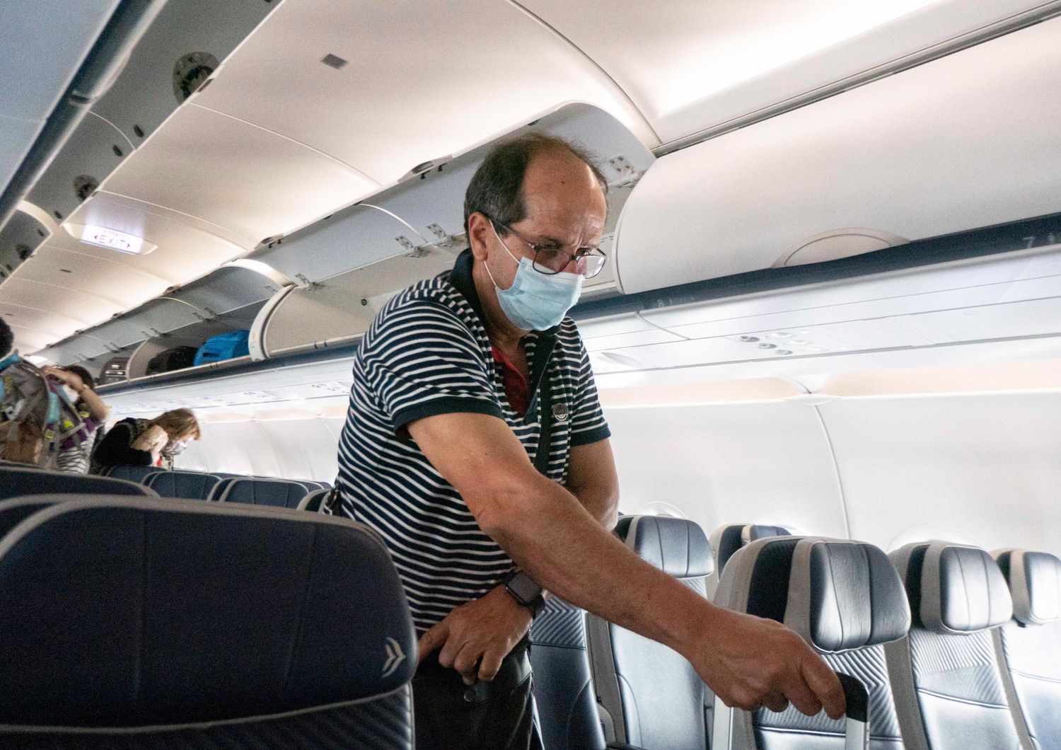 Un passeggero di un aereo indossa la mascherina