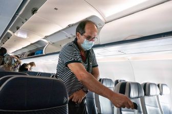 Un passeggero di un aereo indossa la mascherina