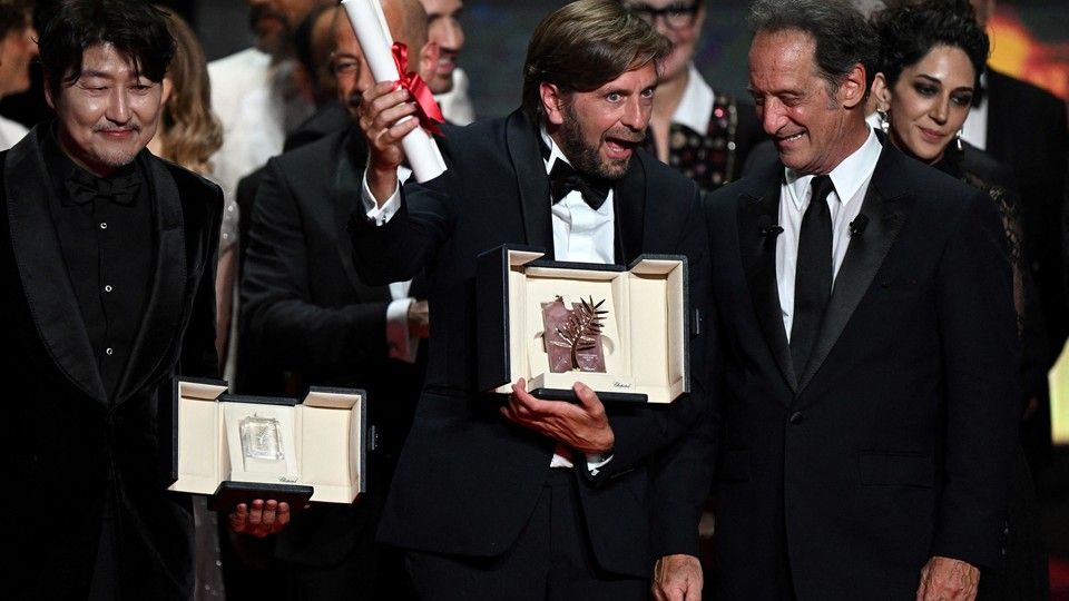 Ruben Ostlund riceve la Palma d'Oro dal presidente della giuria Vincent Lindon