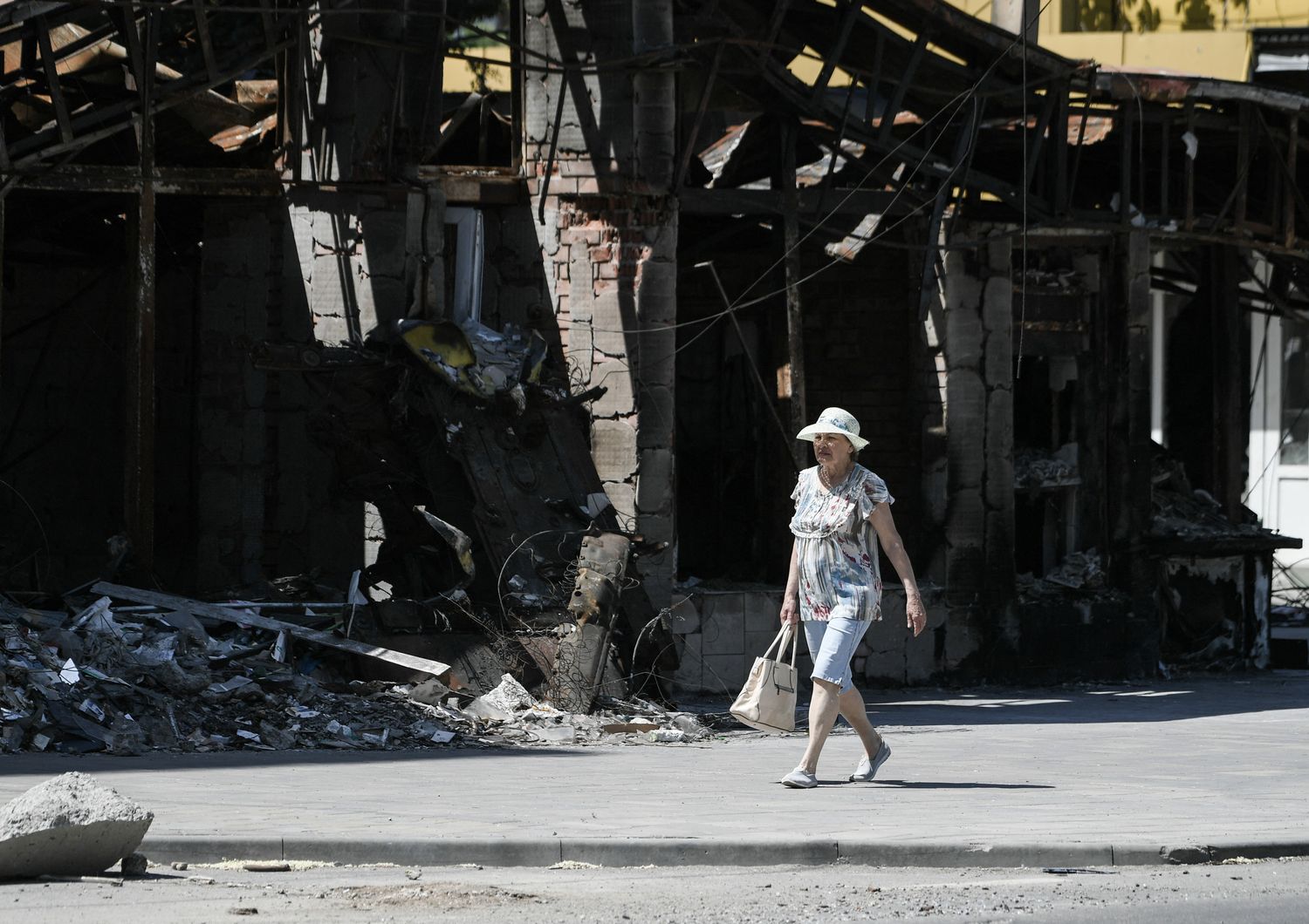 Una donna ucraina cammina per le strade di Mariupol