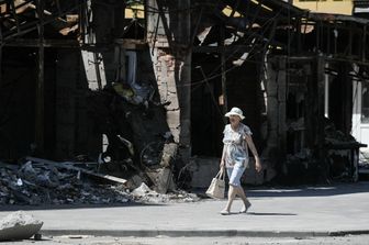 Una donna ucraina cammina per le strade di Mariupol