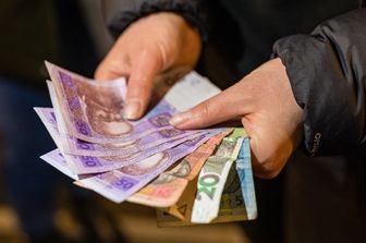 Una donna mostra le banconote ucraine