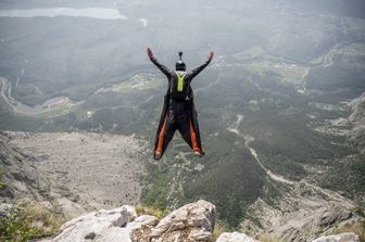 Il lancio di un base jumper da una cima in Trentino