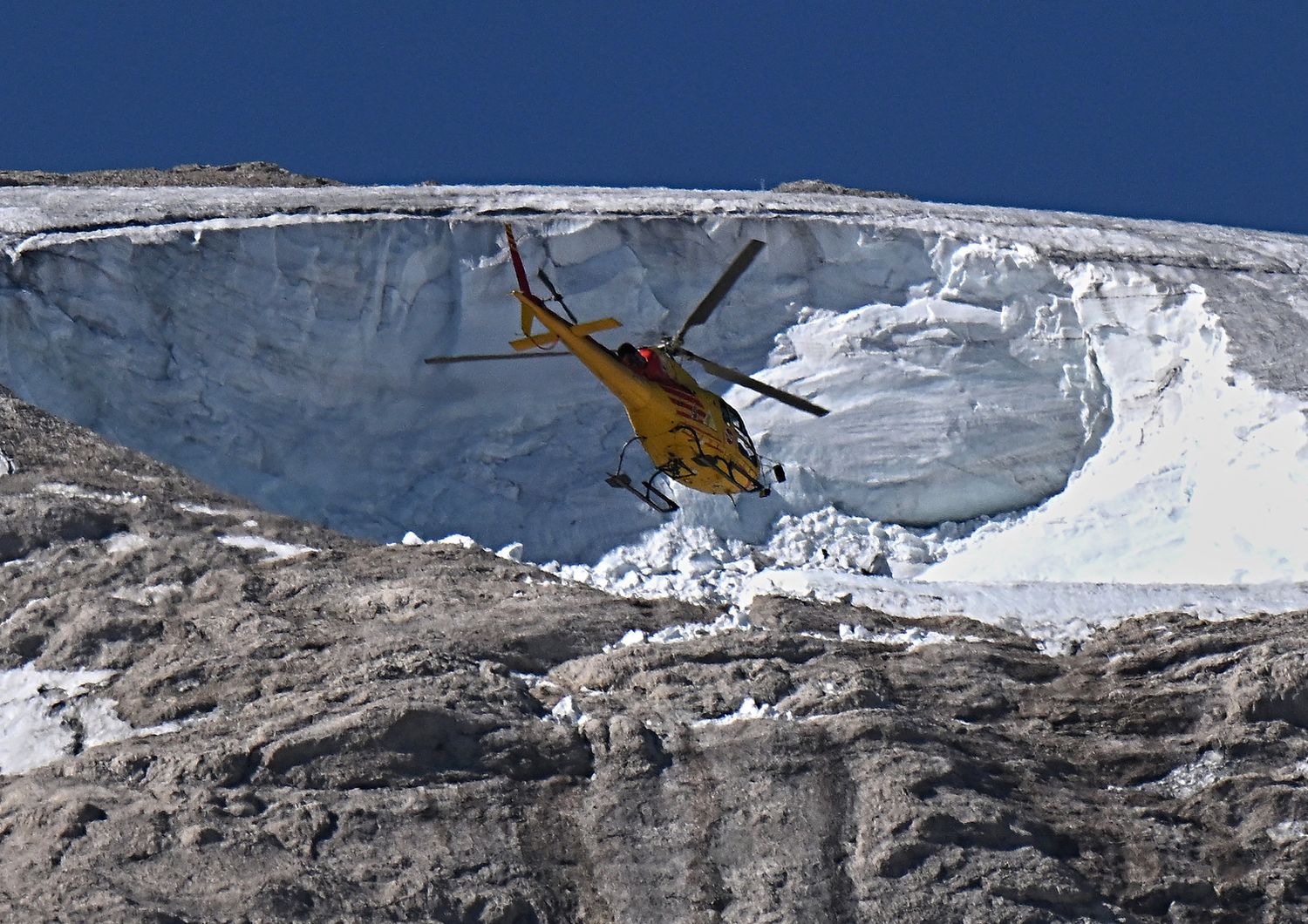 Un elicottero sorvola la zona del disastro della Marmolada