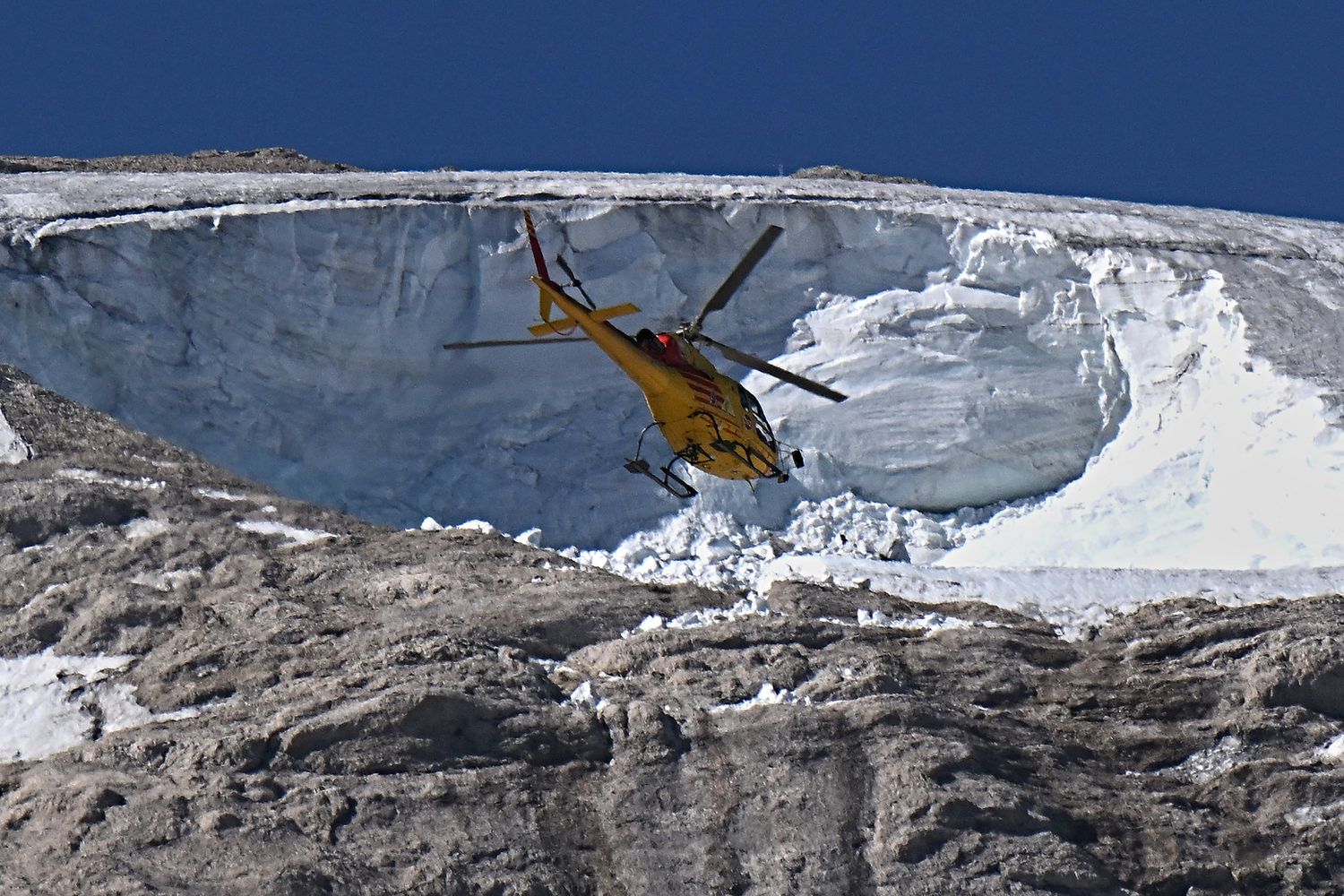Un elicottero sorvola la zona del disastro della Marmolada