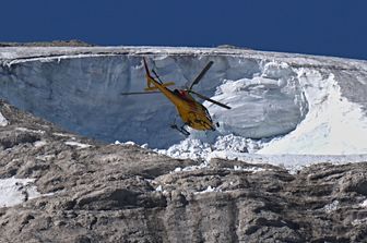 Un elicottero sorvola la zona del disastro della Marmolada