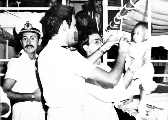 Un medico della missione di salvataggio italiana visita un bambino vietnamita soccorso in mare