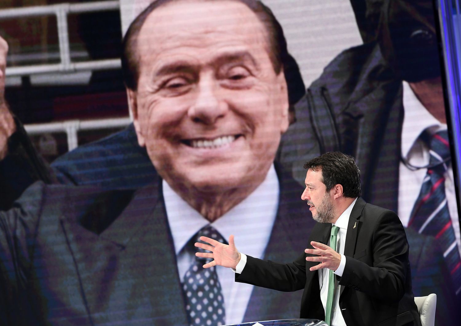 Matteo Salvini con lo sfondo di un'immagine di Silvio Berlusconi&nbsp;