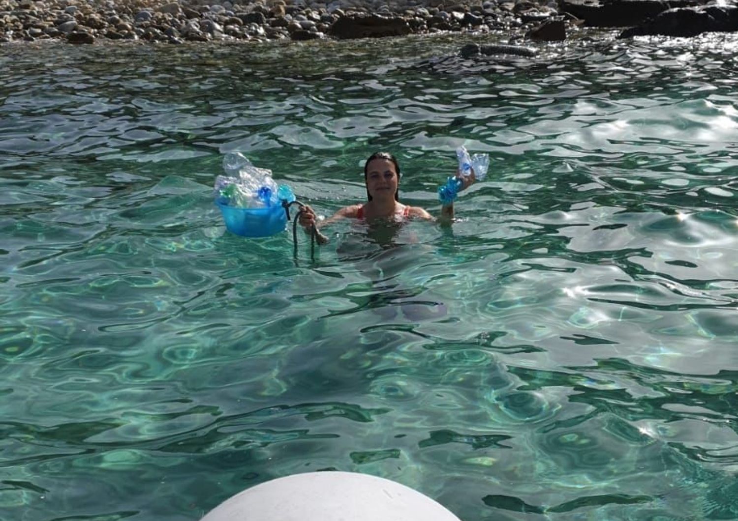Silvia Spano mentre raccoglie rifiuti di plastica in acqua nel Sud Sardegna
