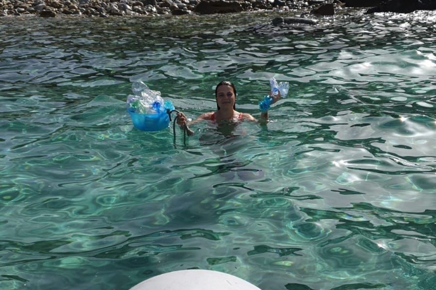 Silvia Spano mentre raccoglie rifiuti di plastica in acqua nel Sud Sardegna