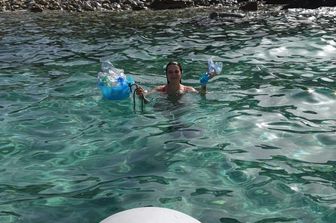 Silvia Spano mentre raccoglie rifiuti di plastica in acqua nel Sud Sardegna