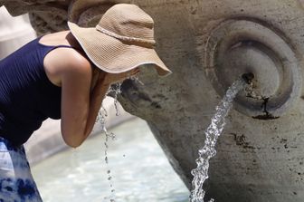 Una turista si rinfresca alla fontana della Barcaccia in Piazza di Spagna.&nbsp;