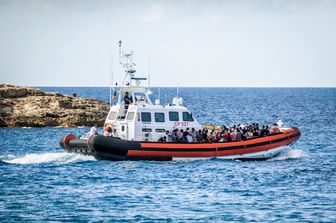 Migranti arrivano a Lampedusa su un'imbarcazione della Guardia di Finanza