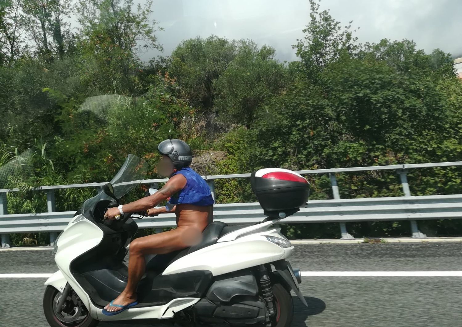 Un uomo su uno scooter con un casco.