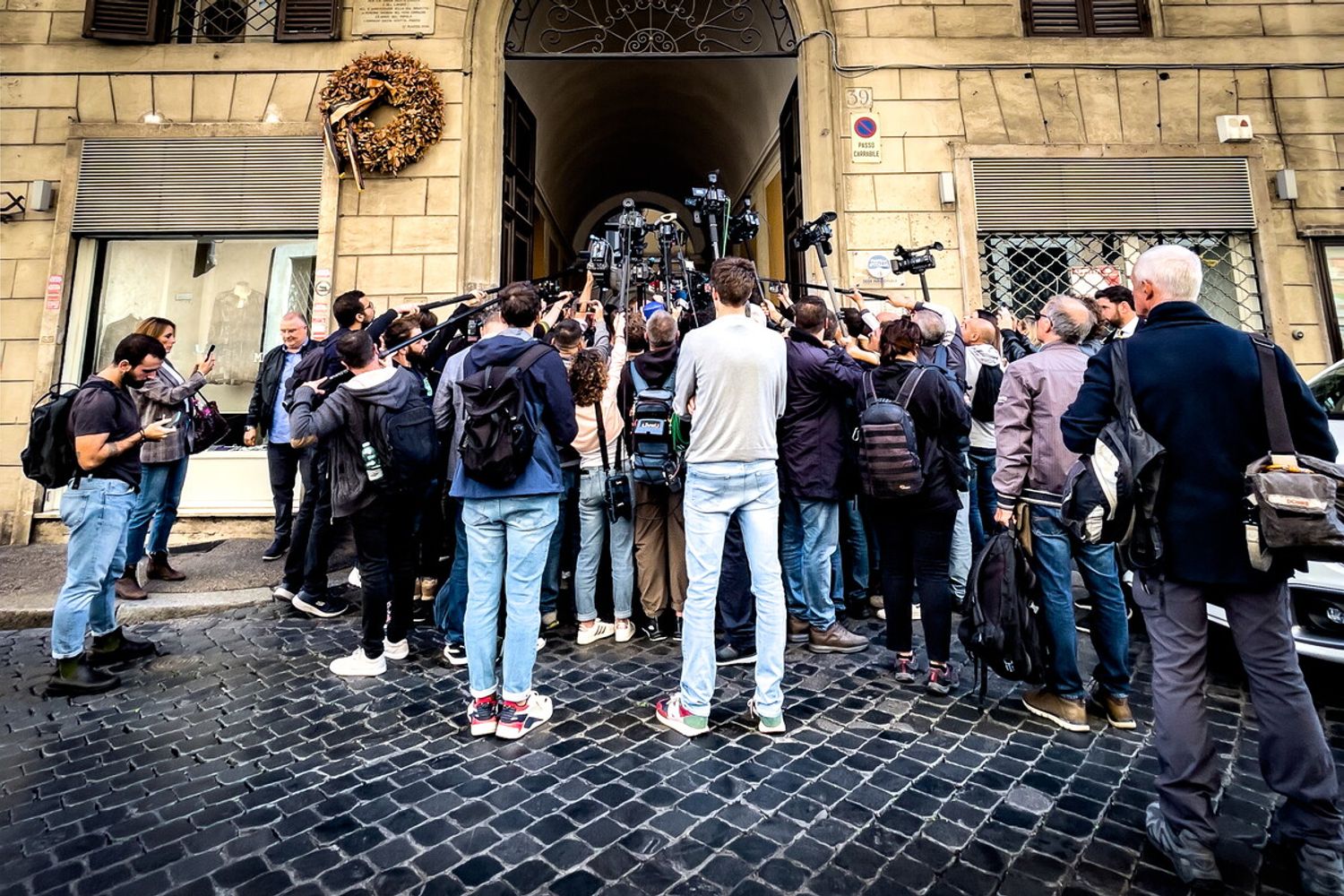 Folla di giornalisti e curiosi davanti alla sede di Fratelli d'Italia