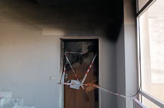 La porta dell'appartamento di Catanzaro distrutto dall'incendio in cui sono morti tre fratelli