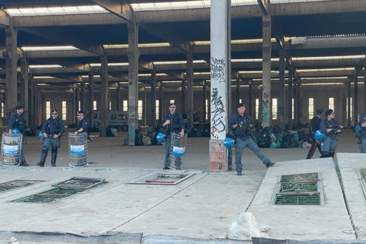 Poliziotti schierati davanti al capannone del rave party di Modena