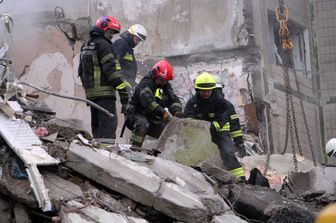 I soccorritori scavano tra le macerie del condominio colpito a Dnipro da un missile russo