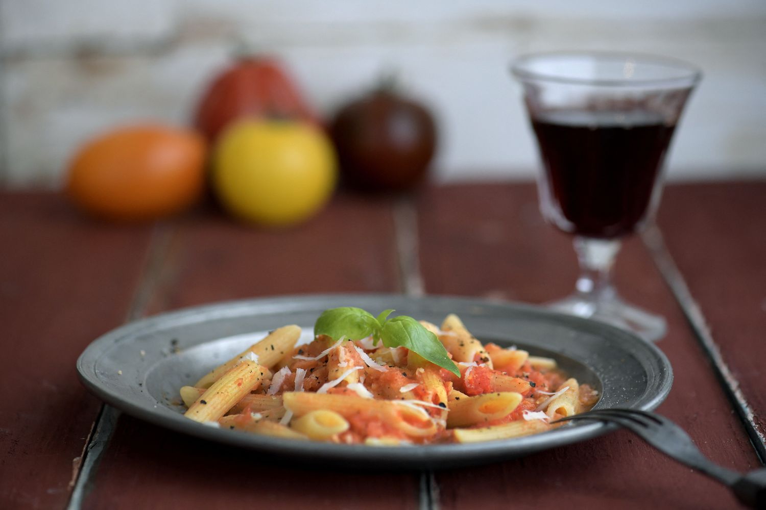 Un piatto di pasta accompagnato da un bicchiere di vino