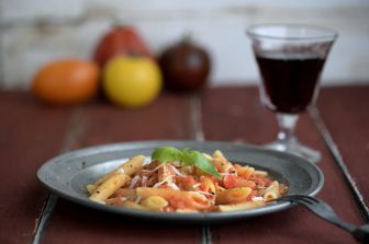 Un piatto di pasta accompagnato da un bicchiere di vino