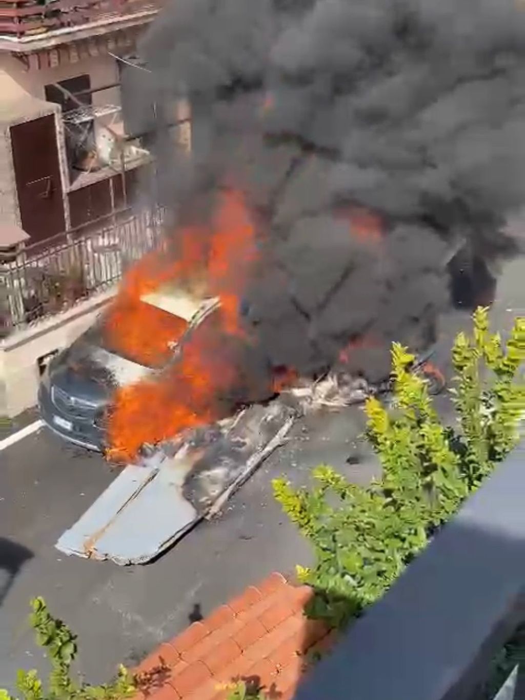 I resti di un aereo in fiamme finito contro un'auto