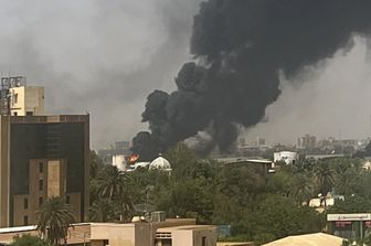 Una colonna di fumo si alza dagli edifici durante gli scontri a Khartoum