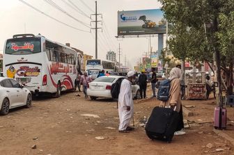 Civili in fuga dal Sudan cercano di salire su un pullman
