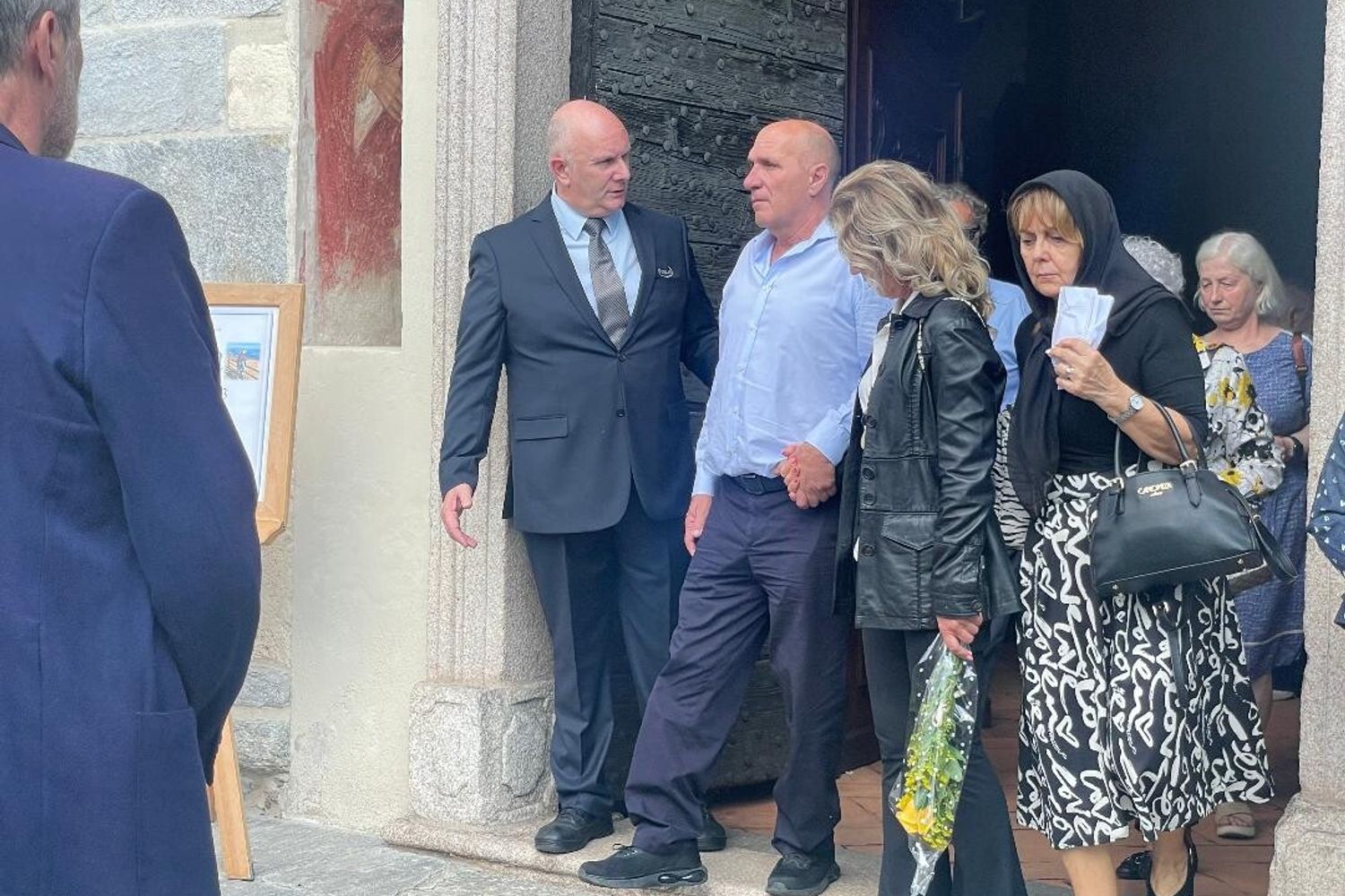 Carminati, in camicia bianca, lascia la chiesa dopo le esequie della mooglie