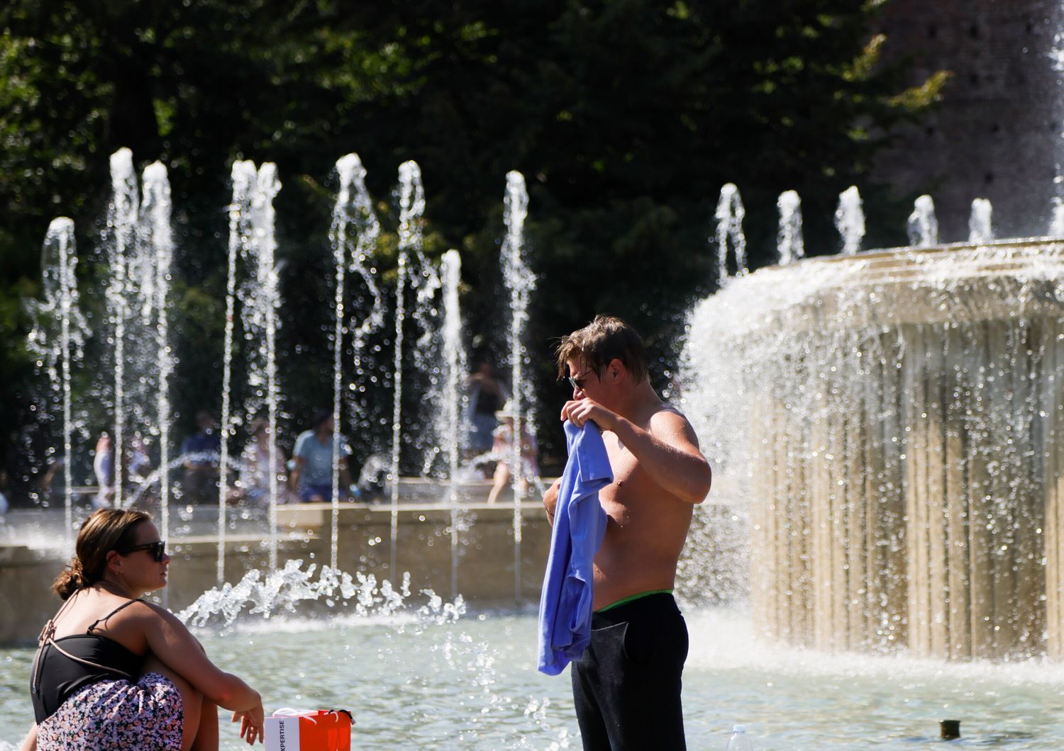 Caldo: milanesi si rinfrescano nella fontana di Piazza Castello