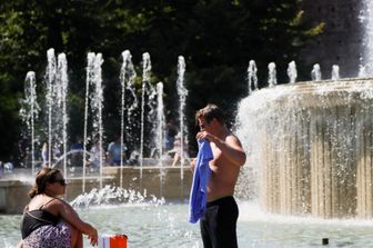 Caldo: milanesi si rinfrescano nella fontana di Piazza Castello