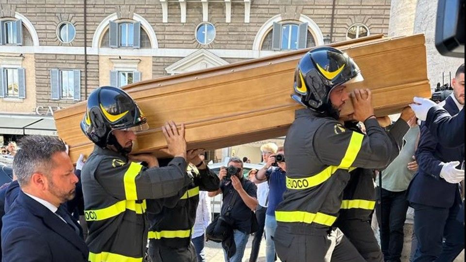 Il feretro di Purgatori portato a spalla dai vigili del fuoco