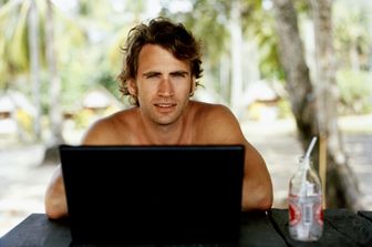 Uomo al lavoro con il suo pc mentre sta in vacanza&nbsp;