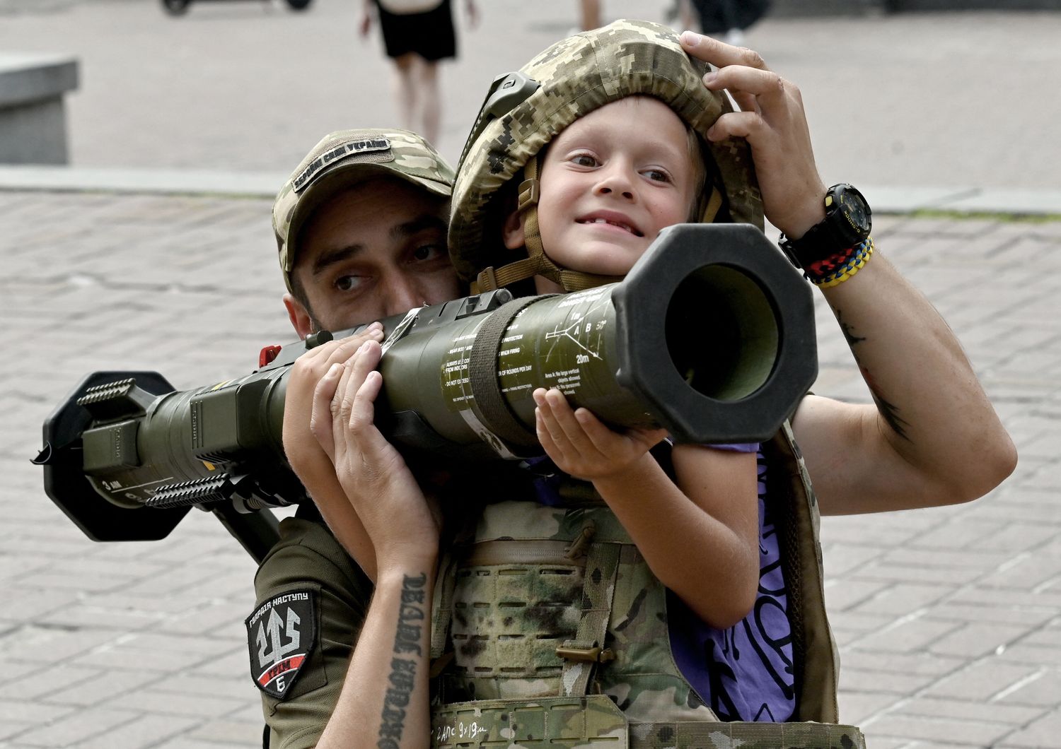 Un soldato ucraino aiuta un bambino a sollevare un'arma anti-carro&nbsp;