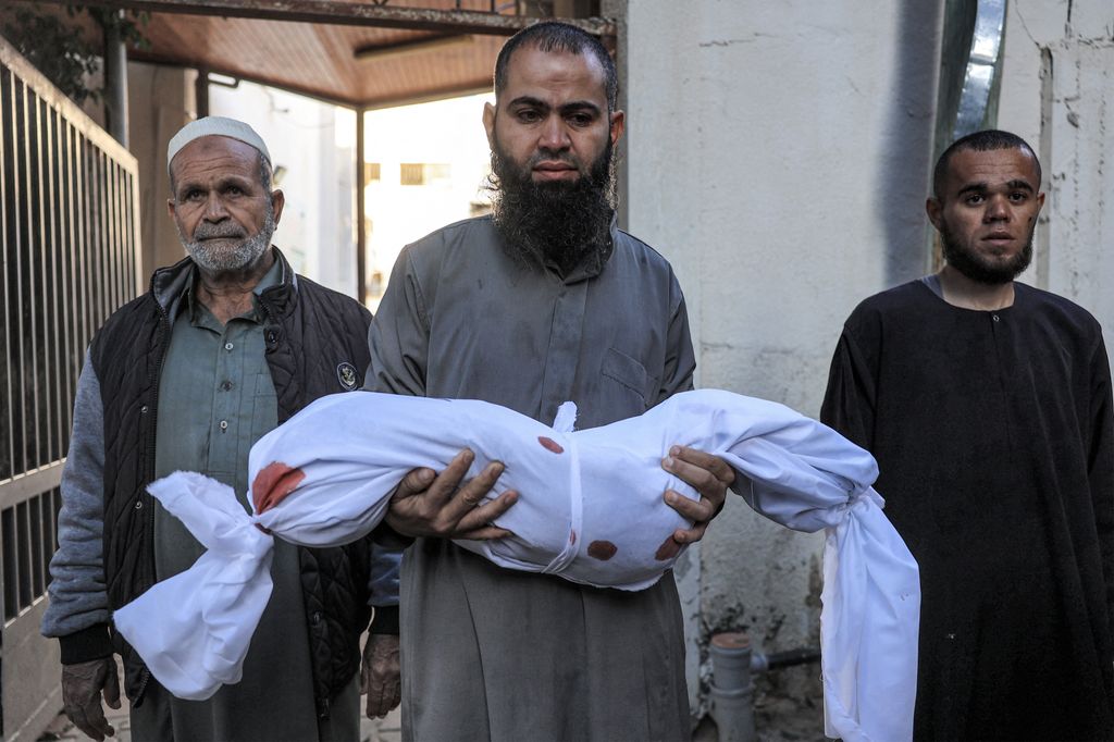 Un uomo con il cadavere della figlia perita in un bombardamento israeliano