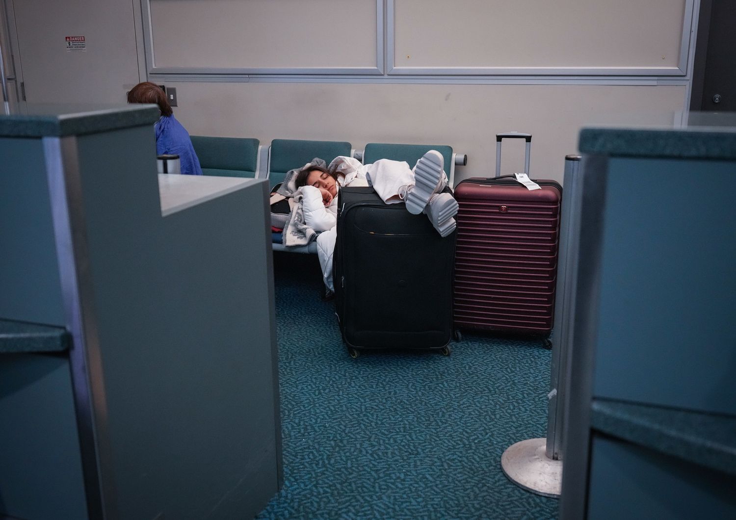Una persona dorme in aeroporto (immagine di repertorio)